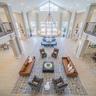 Spacious and elegant living room with modern decor and a high ceiling.