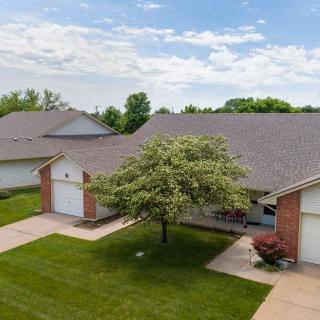 A suburban home with a well-maintained lawn and a tree in the front yard.