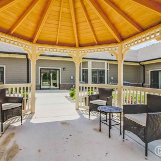 A cozy gazebo with outdoor seating, providing a shaded area in the backyard.