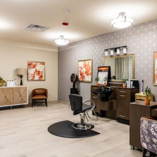 A beautifully designed hair salon featuring modern furniture and elegant lighting.