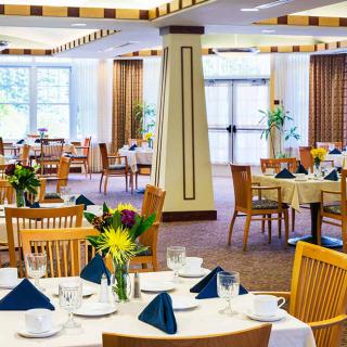 A well-arranged restaurant dining area with neatly set tables and decorative flowers.