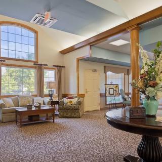 A cozy lobby area with comfortable seating and large windows letting in natural light.