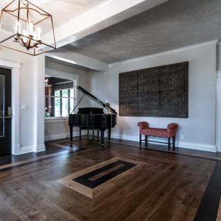 A modern living room featuring a grand piano and stylish decor.
