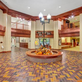 A spacious hotel lobby featuring intricate woodwork and patterned flooring.