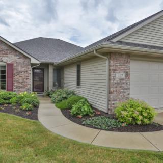 A suburban house with brick and siding exterior, surrounded by a well-maintained lawn and landscaped walkway.