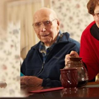 An elderly couple enjoying tea indoors, sharing a warm moment.