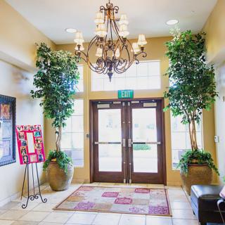 A well-decorated lobby entrance with a chandelier and potted plants.
