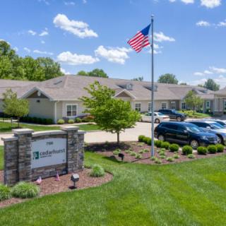 A suburban building with a flagpole and parked cars under a clear blue sky.