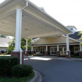 A building entrance with a covered driveway and columns.