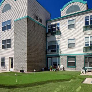 A residential apartment building with a well-maintained lawn in the foreground.