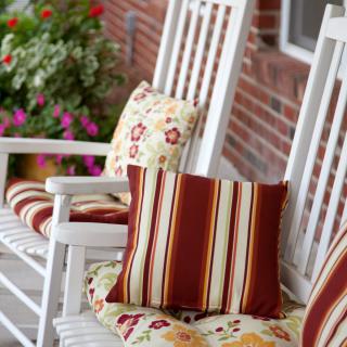 Cozy rocking chairs with patterned cushions on a porch.