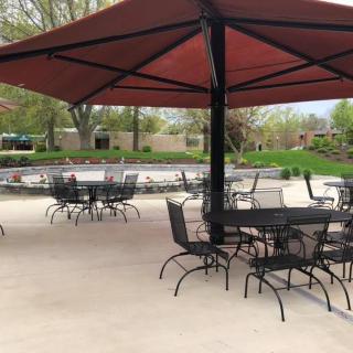 An outdoor patio area with tables, chairs, and large umbrellas.