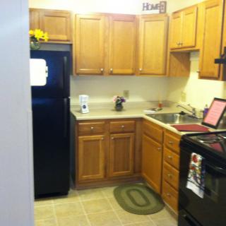 A cozy kitchen with wooden cabinets and standard appliances.