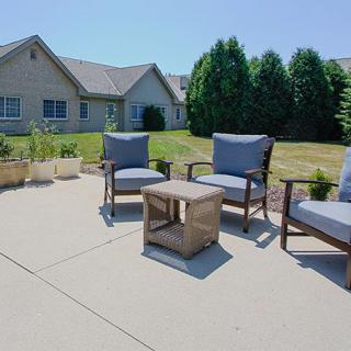 Outdoor patio setup with chairs and a table in a residential backyard.