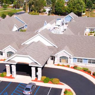 An aerial view of a residential building with a well-maintained parking lot and landscaping.