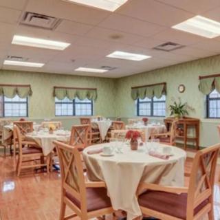 An inviting dining room with round tables and neatly arranged chairs, set for a meal.