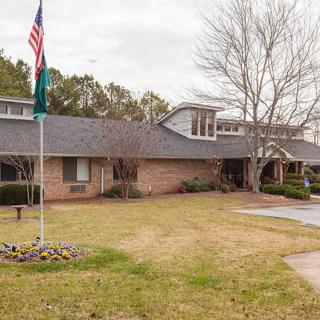 A suburban house with a flagpole and a well-maintained lawn.