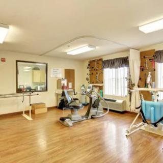 A well-lit exercise room with various fitness equipment for therapy and rehabilitation.