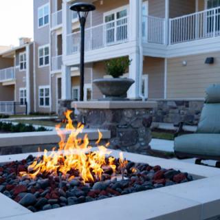 A cozy fire pit in the outdoor area of a modern apartment complex.