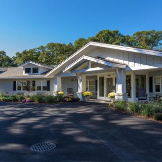 A residential house with a well-maintained front yard on a sunny day.