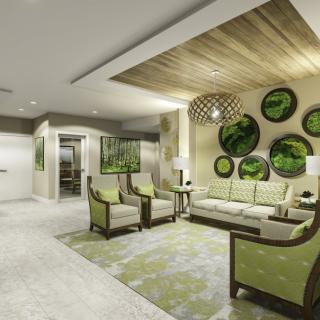 A modern lobby with elegant furniture and green accent decor.
