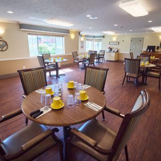 A cozy dining room with neatly arranged tables and chairs, set for a meal.