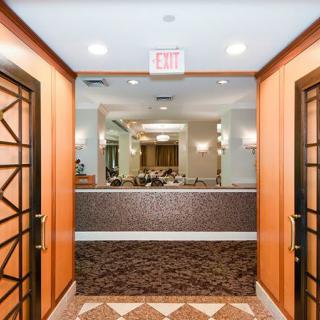 A well-lit hotel lobby entrance with elegant decor and a patterned floor.