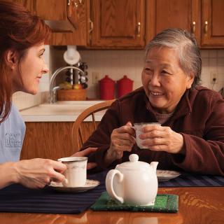Two women enjoying a conversation over tea in the kitchen.