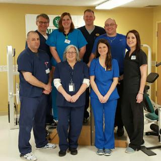 A dedicated team of healthcare professionals posed together in their clinic.