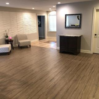 A spacious, well-lit living room interior with hardwood flooring and minimalist decor.