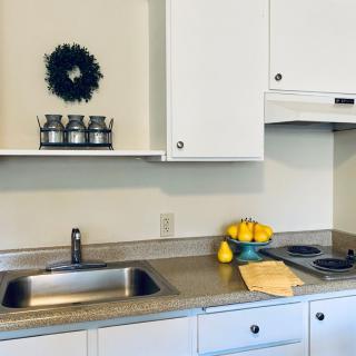 A modern kitchen with white cabinets, a sleek countertop, and decorative elements including lemons in a bowl.