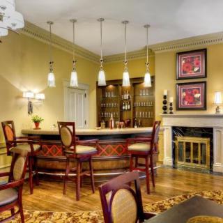 A stylish home bar with elegant seating, pendant lighting, and decorative elements.