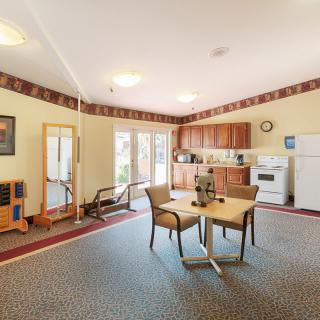 A cozy living space featuring a kitchen area with a table and chairs, set on a carpeted floor.