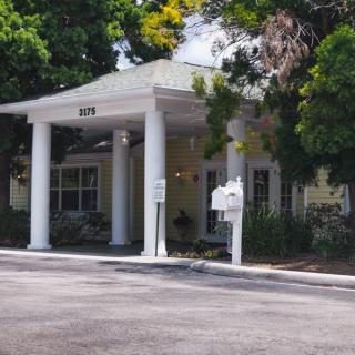 A building entrance with columns surrounded by trees.