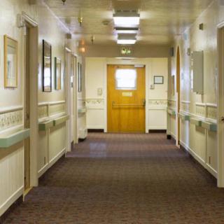 A well-lit hospital hallway with doors on either side.