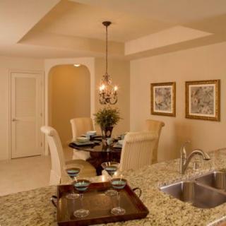 A cozy dining area adjacent to a kitchen with granite countertops and elegant decor.