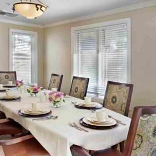 A well-decorated dining room table with a white tablecloth, elegant place settings, and floral centerpieces.
