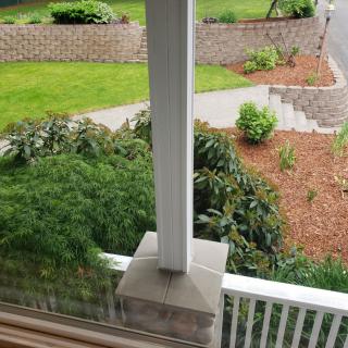 A view from the porch overlooking a well-maintained garden with a pathway.