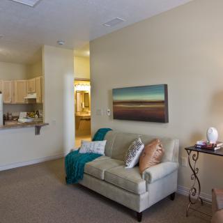 A cozy living room with a sofa, artwork on the wall, and soft lighting.