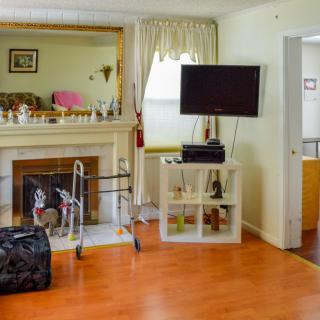 A cozy living room with a fireplace, TV, and various decorations.