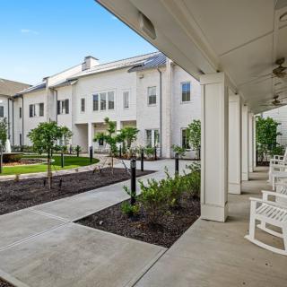 A serene courtyard area with a covered walkway and outdoor seating.