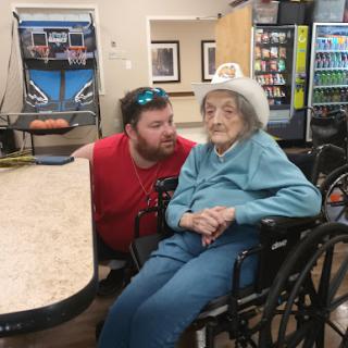 A heartwarming moment shared between a man and an elderly woman in a care facility.