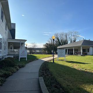 A peaceful outdoor view featuring a pathway lined by buildings under a clear blue sky.