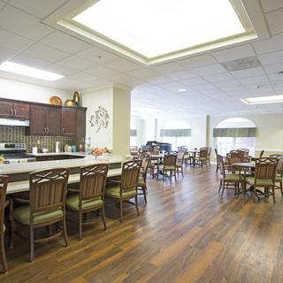 A spacious dining area with wooden flooring and ample seating arrangements.