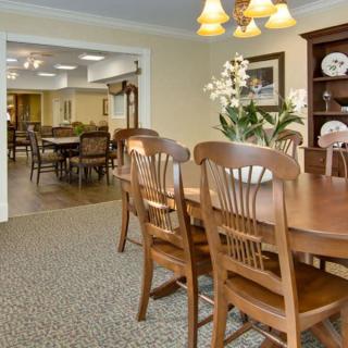 A cozy dining room featuring wooden furniture and elegant lighting.