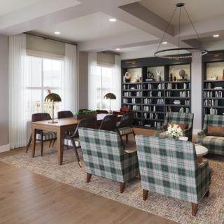 Cozy living room with plaid chairs, bookshelves, and natural light.