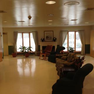 A cozy living room area with a fireplace, comfortable seating, and large windows.