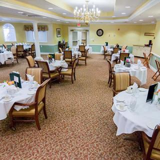 An elegant dining room with neatly arranged tables and chairs, set for a meal.