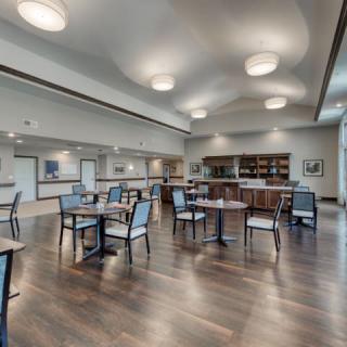 A modern dining area with wooden flooring and contemporary lighting.