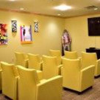 A cozy home theater room featuring rows of bright yellow chairs and vibrant wall art.